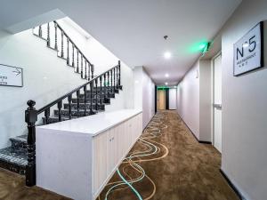 a long hallway with stairs and a long hose at Xana Hotel Guiyang International Convention and Exhibition Center Financial City Store in Guiyang