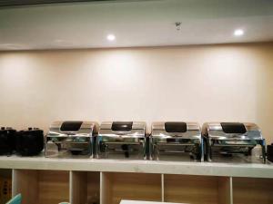 einer Reihe von Behältern aus nichtrostendem Stahl auf einer Theke in der Unterkunft Xana Hotel Guiyang International Convention and Exhibition Center Financial City Store in Guiyang