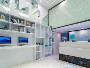 ein Wohnzimmer mit einem Fernseher an der Wand in der Unterkunft Xana Hotel Guiyang International Convention and Exhibition Center Financial City Store in Guiyang