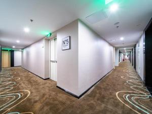 einen Flur eines Büros ohne Schild an der Wand in der Unterkunft Xana Hotel Guiyang International Convention and Exhibition Center Financial City Store in Guiyang + 1 Foto