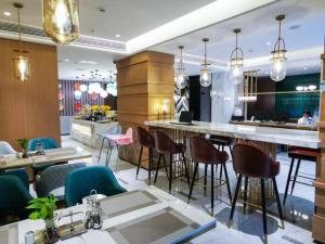 um restaurante com bar e algumas cadeiras e mesas em Magnotel guiyang fountain commercial center subway station hotel em Guiyang