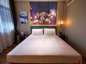 Säng eller sängar i ett rum på Magnotel guiyang fountain commercial center subway station hotel