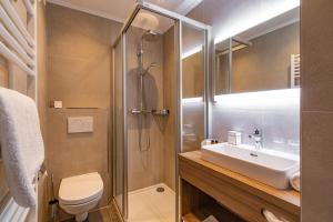 ein Badezimmer mit Dusche, Toilette und Waschbecken in der Unterkunft Superior Hotel Persal in Finkenberg