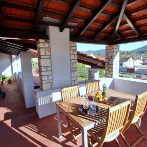 a wooden table and chairs on a patio at Apartment Lucija in Vela Luka