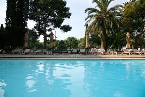 a large swimming pool with chairs and umbrellas at Hotel Trias in Palamós