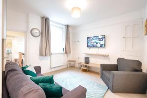a living room with a couch and a tv at Working in Swansea - Try us out in Swansea