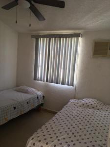 a bedroom with two beds and a window with blinds at casa en Acapulco diamante con alberca y todos los servicios in La Sabana