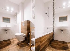 two images of a bathroom with a toilet and a sink at Apartamenty Maestro in Gdynia