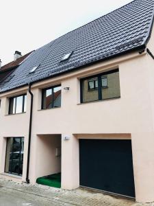 uma casa branca com uma porta de garagem preta em Noblesse Hause em Gammertingen