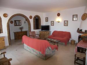 a living room with a red couch and a tv at Nerja Villas-Capistrano in Nerja