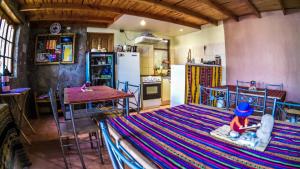 a kitchen with a bed and a table and a refrigerator at Sol del Desierto in Chíuchíu