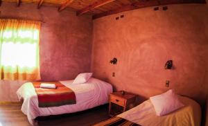 1 dormitorio con 2 camas y ventana en Sol del Desierto, en Chíuchíu