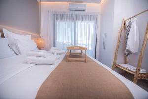 una habitación blanca con una cama y una mesa en Emmeleia mare, en Agia Pelagia 44 fotos más