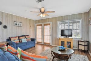 a living room with a blue couch and a tv at Seaside Cottage in Galveston