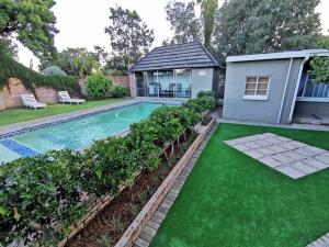 a backyard with a swimming pool and green grass at LemonBlossom in Bloemfontein