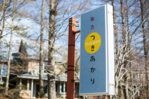 un cartel en un poste delante de una casa en Ryosha Tsukiakari en Yamanakako