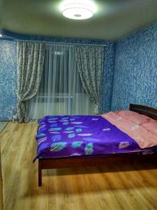 ein Schlafzimmer mit einem lila Bett mit blauen Wänden in der Unterkunft 2х кімнатна квартира на вулиці Лесі Українки in Uzyn