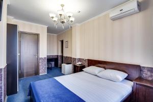 頓河畔羅斯托夫的住宿－戲劇酒店，一间卧室配有一张大床和一个吊灯。