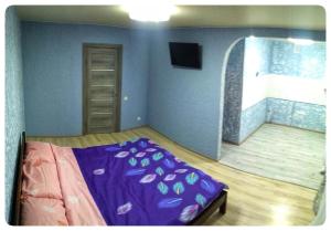 a bedroom with a purple bed in a room at 2х кімнатна квартира на вулиці Лесі Українки in Uzyn