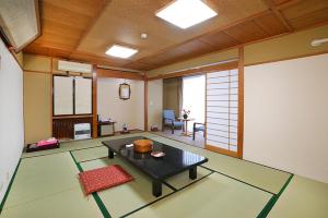 a room with a table in the middle of a room at 楽奇温泉旅館 in Yamanouchi