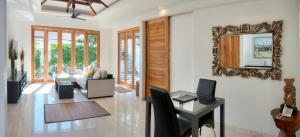sala de estar con sofá, mesa y espejo en Kokomo Resort Gili Gede, en Gili Gede
