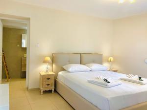 a bedroom with a large white bed with towels on it at George Apartments2 in Vóthon