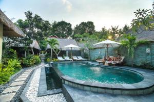 a swimming pool in the middle of a yard at The Nichos Bungalows And Villas in Nusa Lembongan