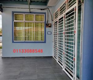 a room with a blue wall and a window at Nas Homestay in Jitra