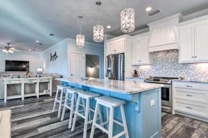 a kitchen with a blue island and white cabinets at Luxe Spacious Stilted Home with Kayaks Walk to Beach in Dauphin Island