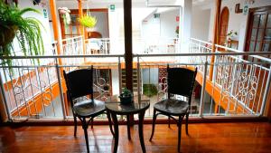 a balcony with two chairs and a glass table at Casa Kuelap Hostal in Chachapoyas