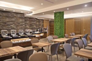 a restaurant with tables and chairs and a green wall at Fengjia Micro Hotel in Taichung
