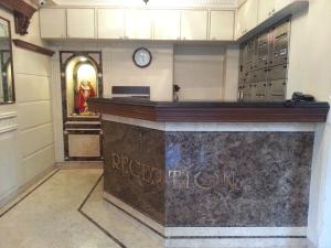 a bar in a store with a clock on the wall at HOTEL ASHRAY INTERNATIONAL, SION - Near BKC in Mumbai
