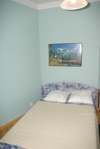 a bed in a room with a painting on the wall at 7k - Apartmán Zámecký Vrch in Karlovy Vary