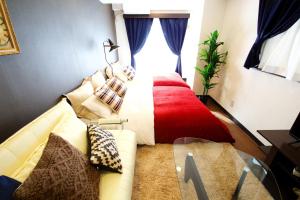 - une chambre avec un lit, un canapé et une fenêtre dans l'établissement Akasaka Koyu Building 801, à Tokyo