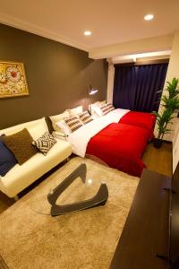 Un dormitorio con una cama roja y blanca y un sofá en Akasaka Koyu Building 801 en Tokio