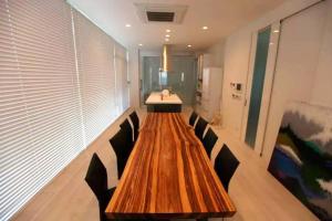 a long wooden table in a room with chairs at Luxury Villa Saitozaki UMIHOTARU in Fukuoka