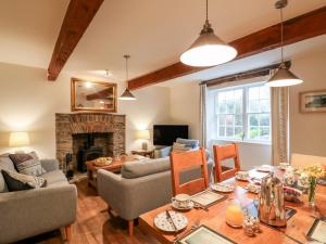 ein Wohnzimmer mit Tisch und Kamin in der Unterkunft Court Prior Cottage in Totnes