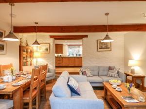 ein Wohnzimmer mit Sofa und Tisch in der Unterkunft Court Prior Cottage in Totnes