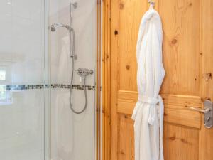ein Badezimmer mit Dusche und einem an der Wand hängenden Handtuch in der Unterkunft Court Prior Cottage in Totnes + 24 Fotos
