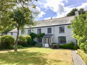 ein weißes Haus mit einem Baum im Hof in der Unterkunft Court Prior Cottage in Totnes