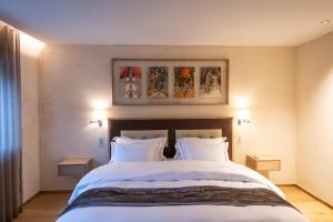 um quarto com uma grande cama branca e 2 almofadas em Auberge Saint Walfrid Hôtel Restaurant & Spa em Sarreguemines