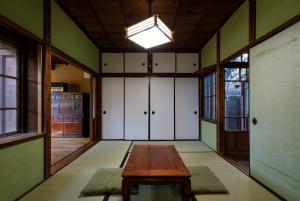 a room with a wooden table and white cabinets at Tsunagian TABI-NE in Kanazawa
