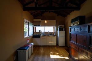 a small kitchen with a white refrigerator and a window at Tsunagian TABI-NE in Kanazawa