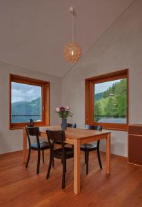 a dining room with a table and chairs and two windows at Pension Laresch in Mathon