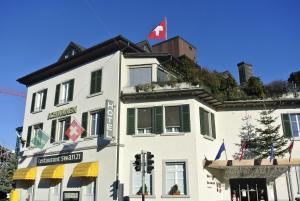 a white building with a flag on top of it at Hotel Schwanen Wil in Wil