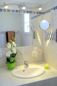 baño con lavabo y jarrón de flores en Atlantic Residence, en Jonzac