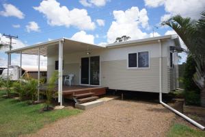 a manufactured home with a porch and a house at Bundaberg Park Village in Bundaberg