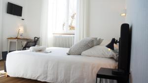 Schlafzimmer mit einem Bett mit weißer Bettwäsche und einem Fenster in der Unterkunft Hotel Savel in Ruoms