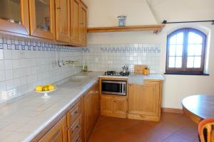 uma cozinha com armários de madeira e uma tigela de fruta no balcão em Agriturismo del Pigato - Bio Vio em Albenga