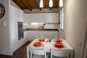 a kitchen with a white table with red dishes on it at La Casa dell Olivo in Castiadas +36 photos